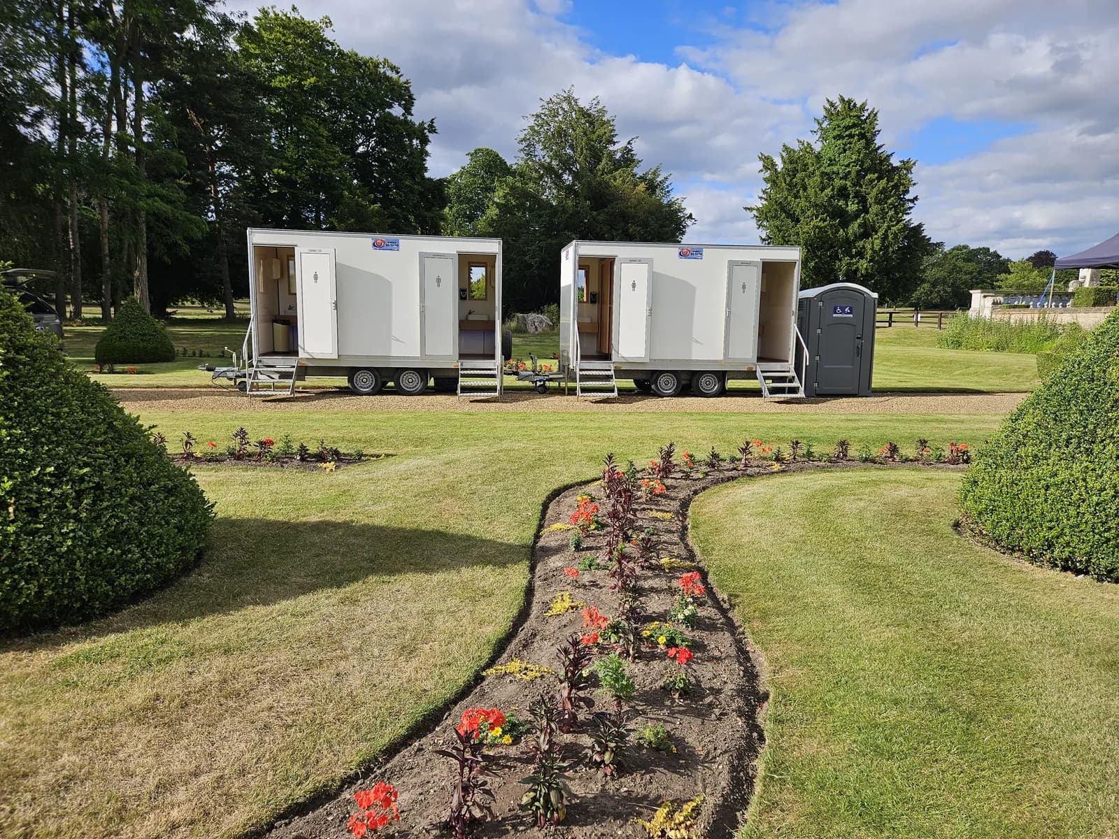 Event toilet blocks set up in formal gardens at a country estate wedding in Suffolk